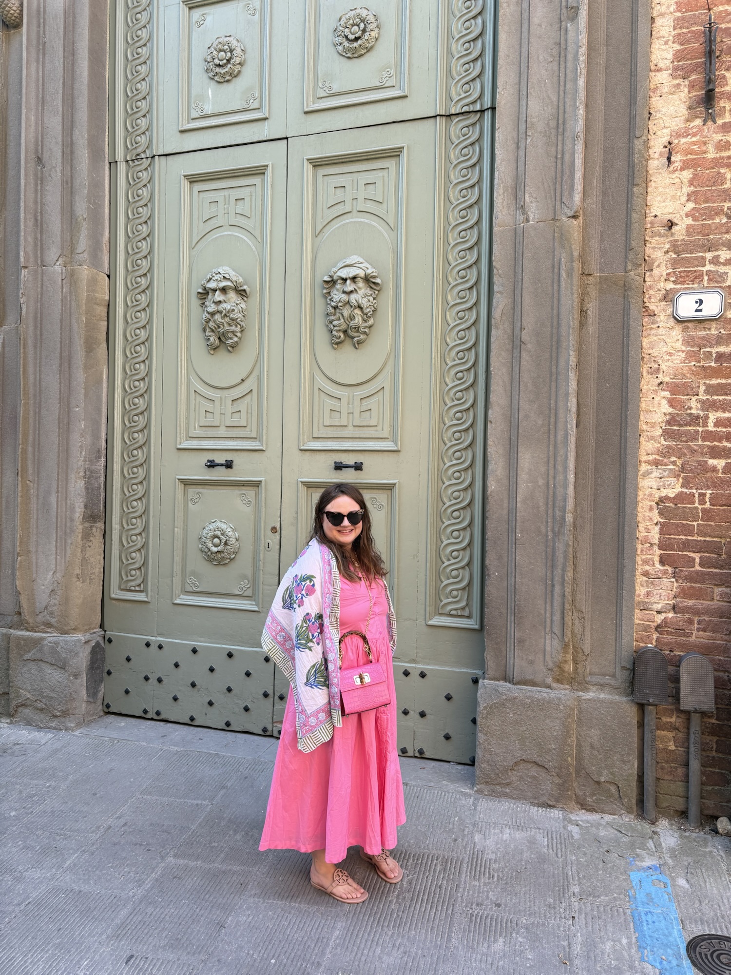 pink chickadee wearing a preppy outfit: pink maxi dress, patterned floral shawl, sunglasses, and tan sandals