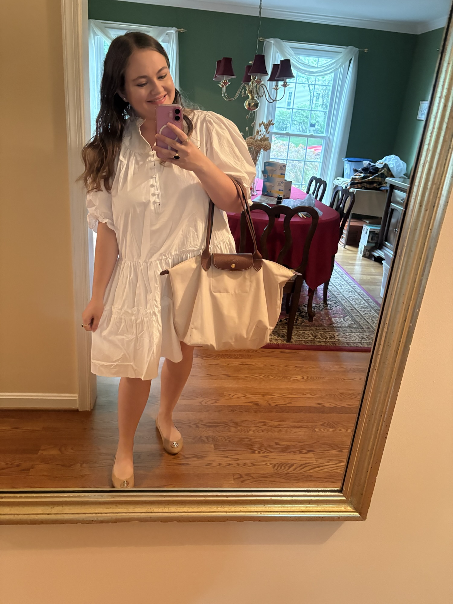 Pink Chickadee in a white tiered dress paired with a neutral beige Longchamp Le Pliage tote bag